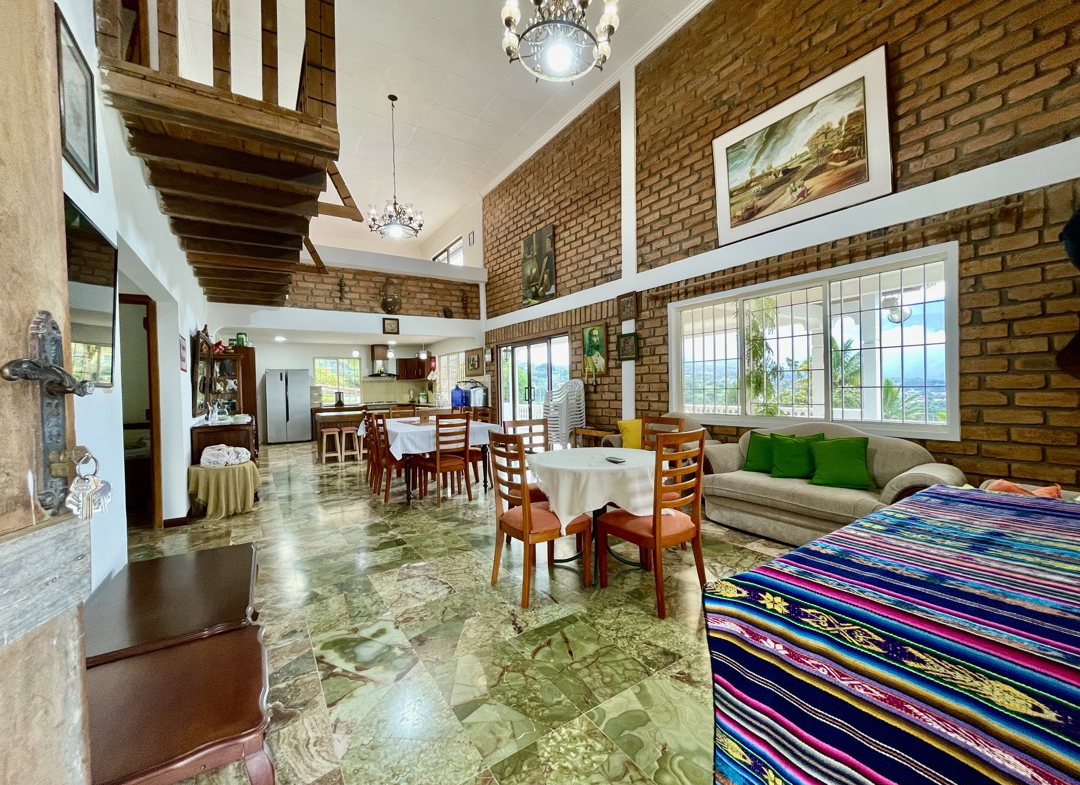 Sala de estar espaciosa y confortable en quinta de Yunguilla, con mobiliario de estilo rústico y chimenea, ideal para noches acogedoras.