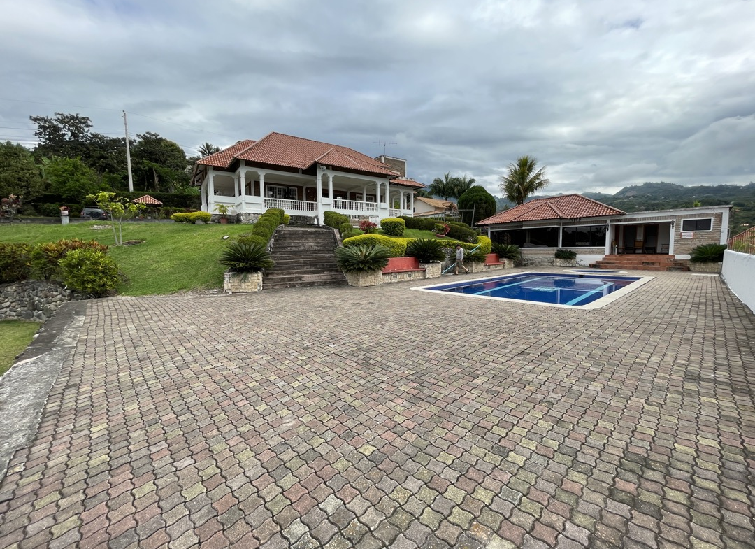 Amplia y refrescante piscina al aire libre en quinta vacacional de Yunguilla, perfecta para relajarse bajo el sol ecuatoriano.